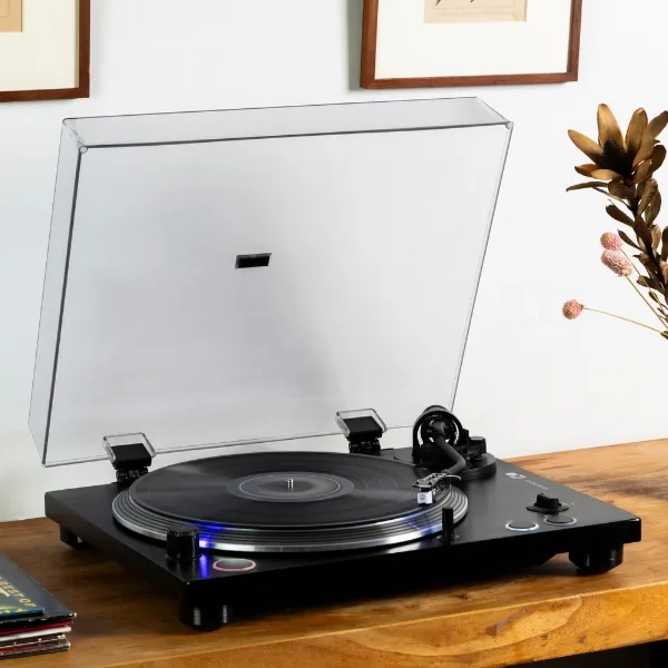 HAKUのレコードプレーヤー。木のテーブルの上、ダストカバーを開けた状態